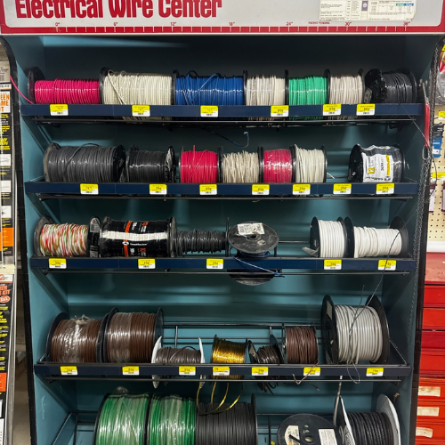 Shelves filled with colorful electrical wire spools are neatly arranged in a store's 