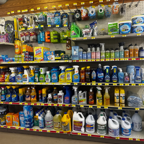 Store shelf filled with cleaning products, including sprays, detergents, and scrubbers. Bottles are brightly colored, creating an organized and tidy display.